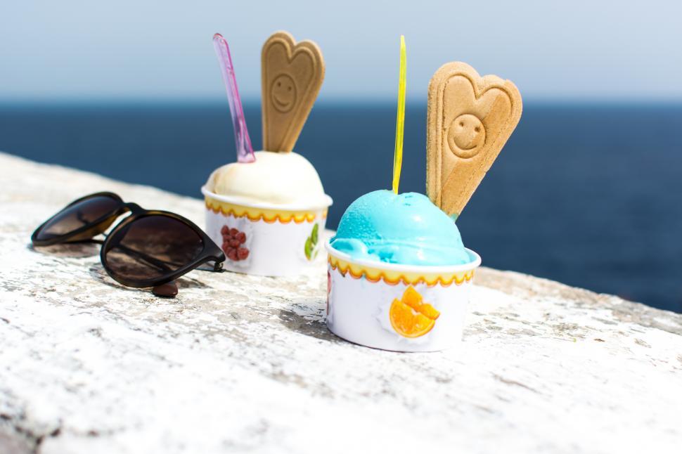 Free Image of Two ice cream cups with cookies and a cookie on top 