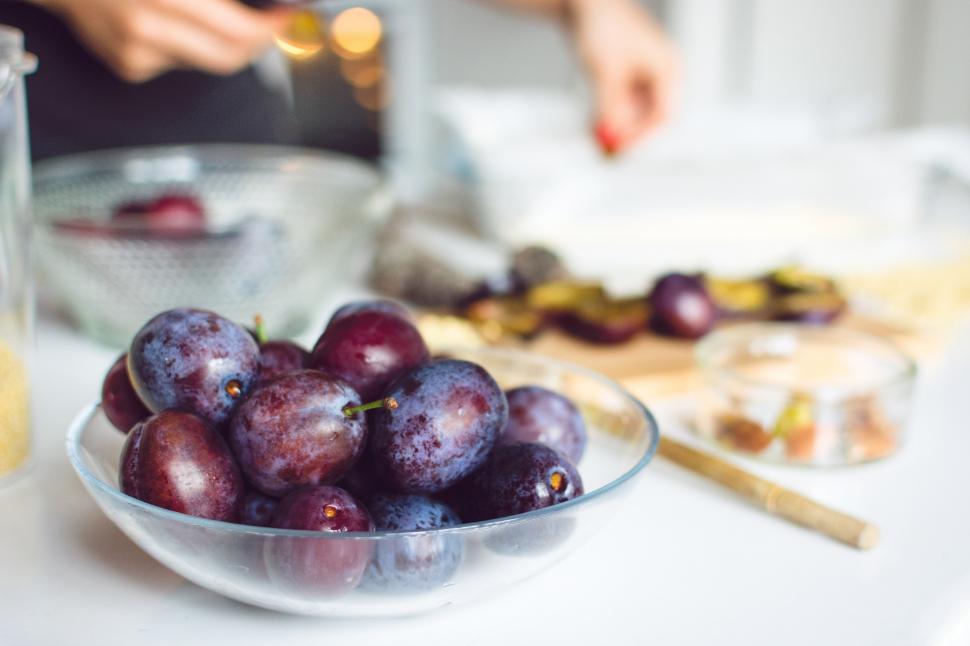 Free Image of A bowl of plums on a table 