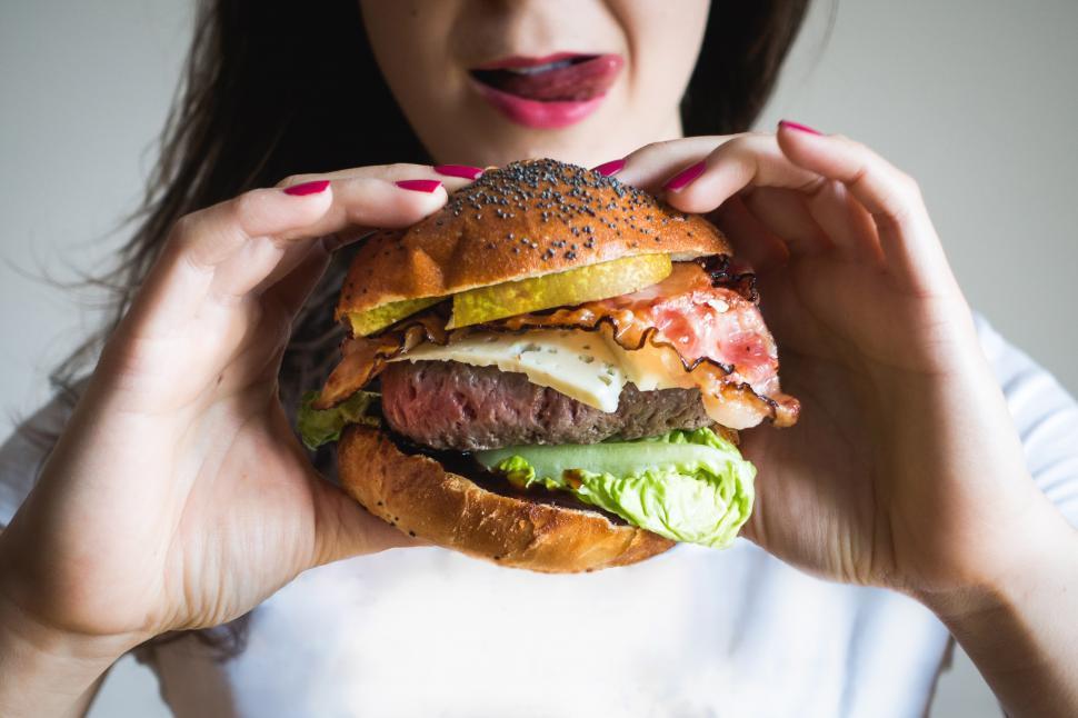 Free Image of A woman holding a burger 