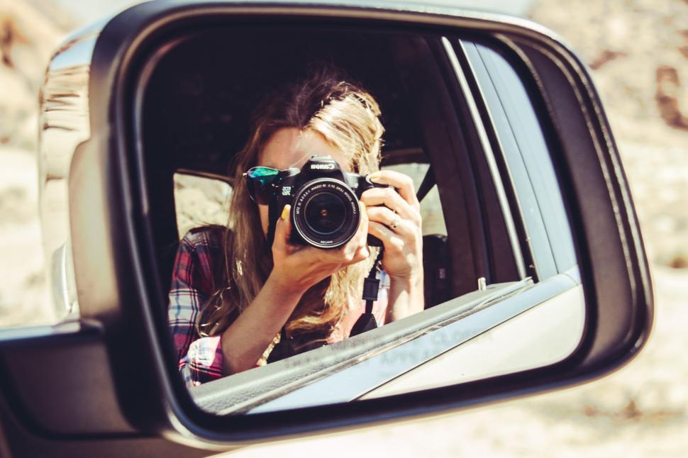 Free Image of A woman taking a picture of herself in a car 