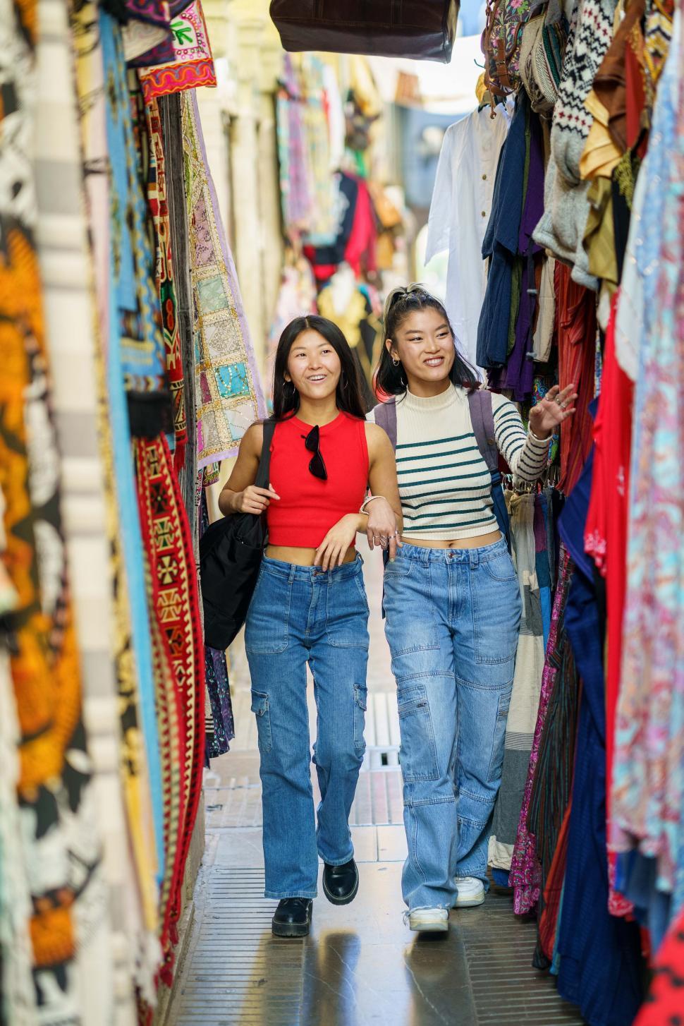 Free Image of Female tourists shopping clothes in street bazaar 