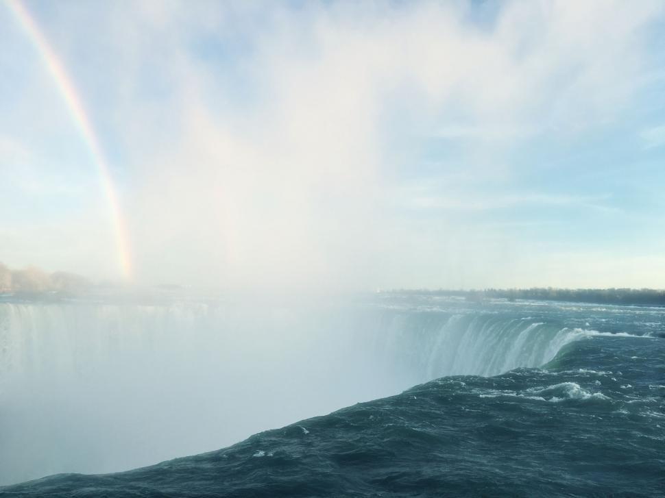 Free Image of A rainbow over a large waterfall 
