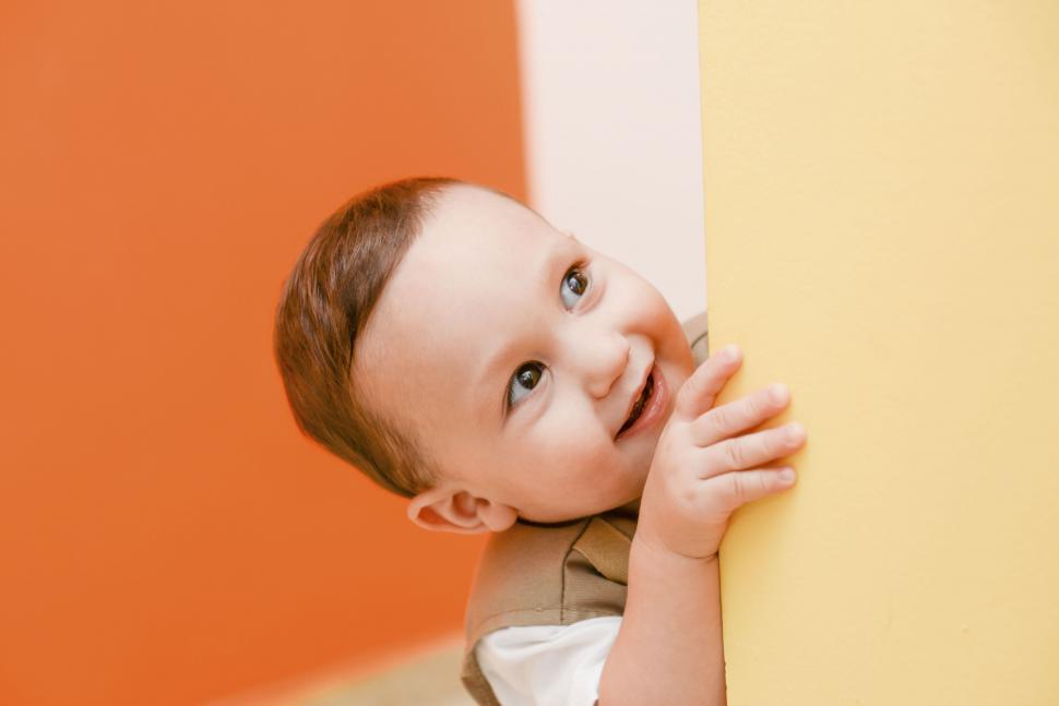 Free Image of A baby looking around a corner 