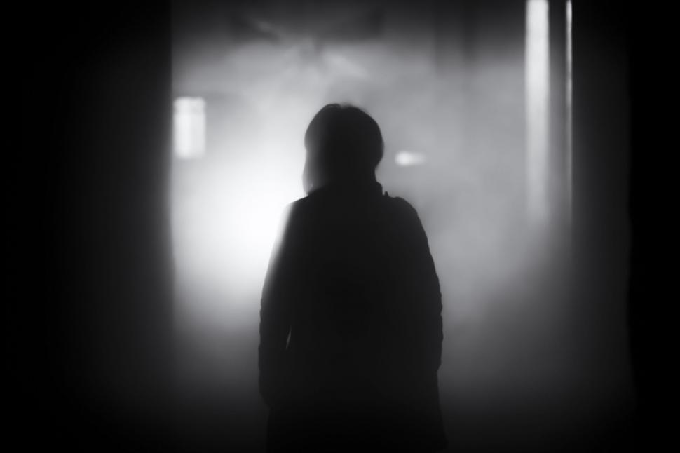 Free Image of A silhouette of a person in a dark room 