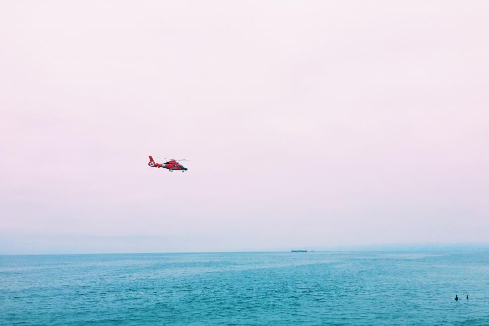 Free Image of A helicopter flying over the ocean 