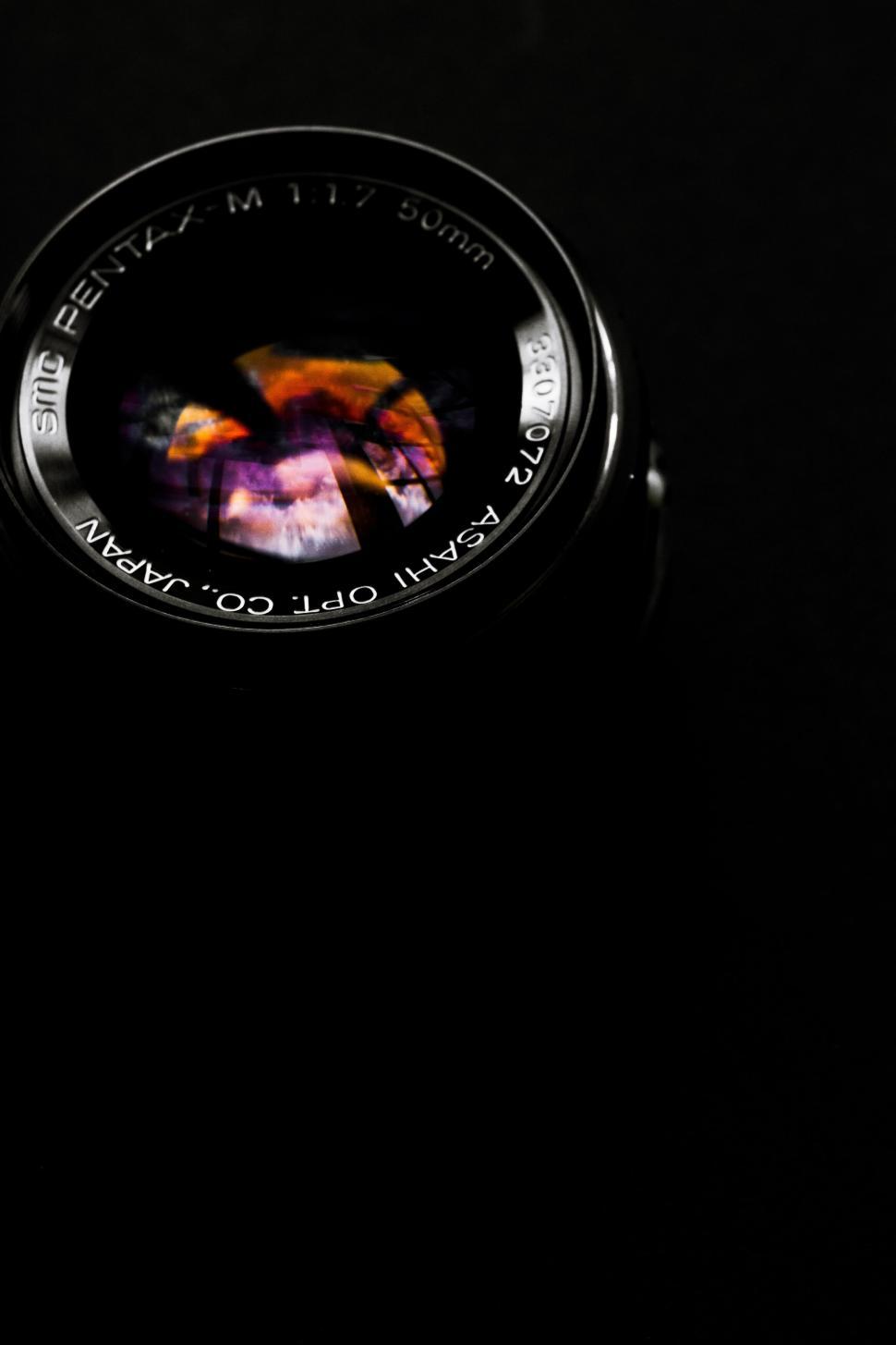 Free Image of A camera lens with a reflection of a colorful sky 