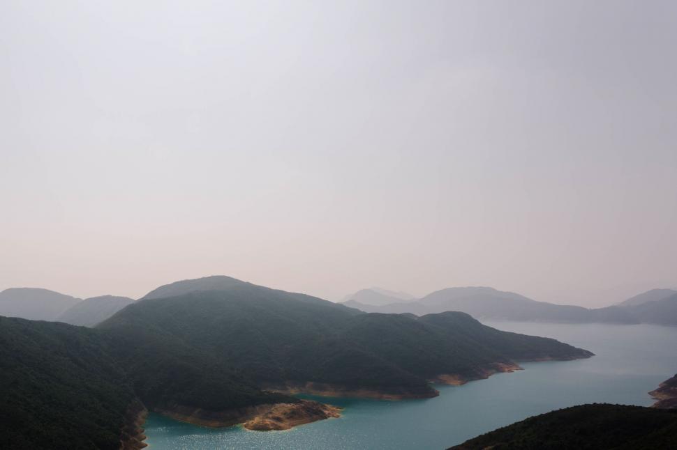 Free Image of A body of water with hills and a blue sky 