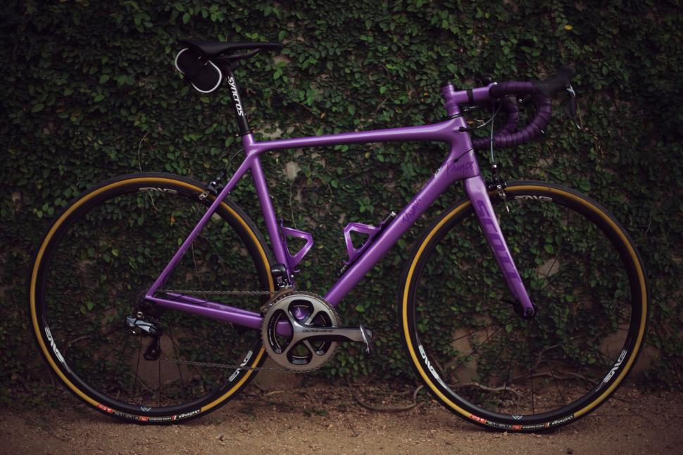 Free Image of A purple bicycle leaning against a wall 
