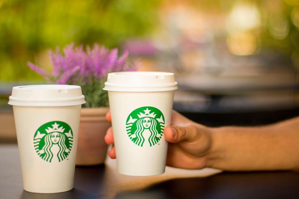 Free Image of A hand holding two cups of coffee 