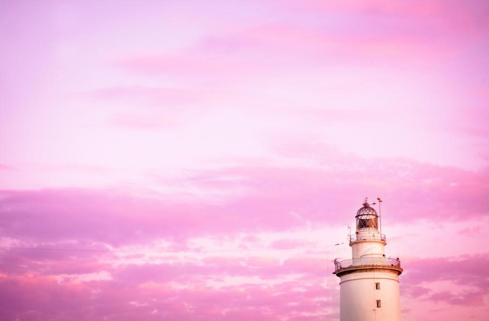 Free Image of A lighthouse with a pink sky 