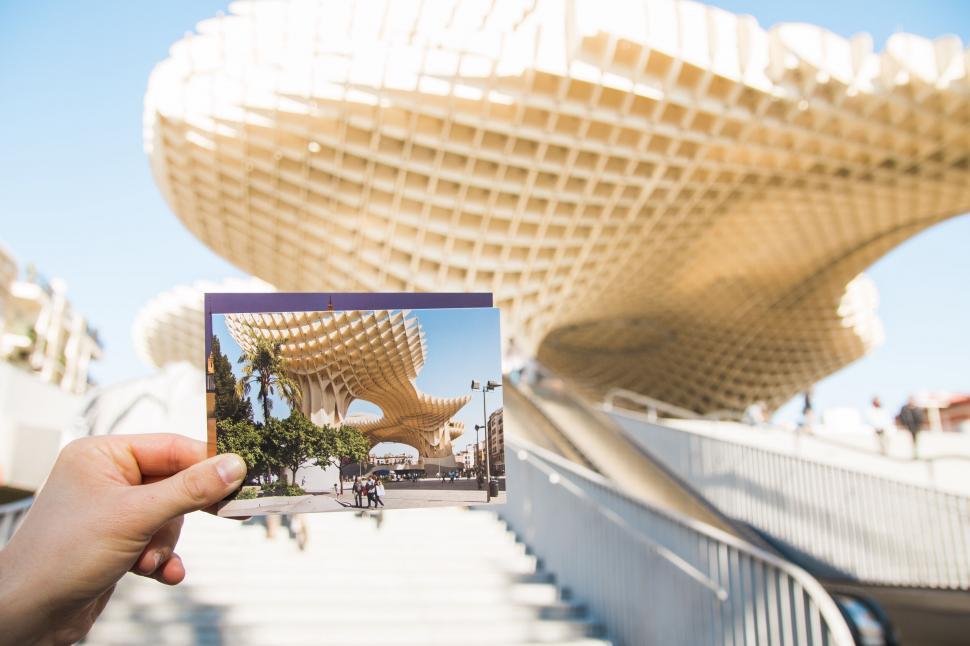 Free Image of A hand holding a photo of a building 