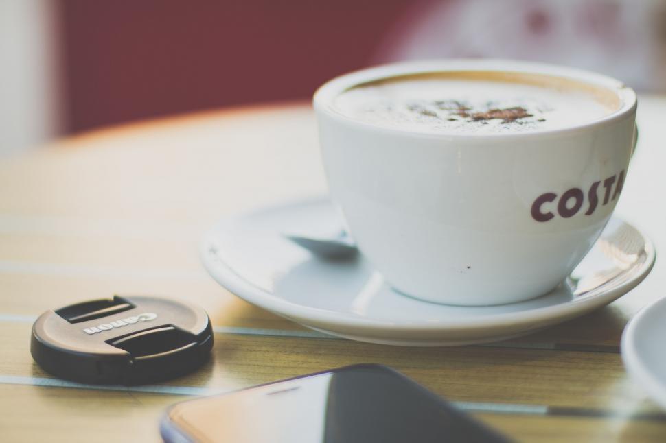 Free Image of A cup of coffee and a phone on a table 