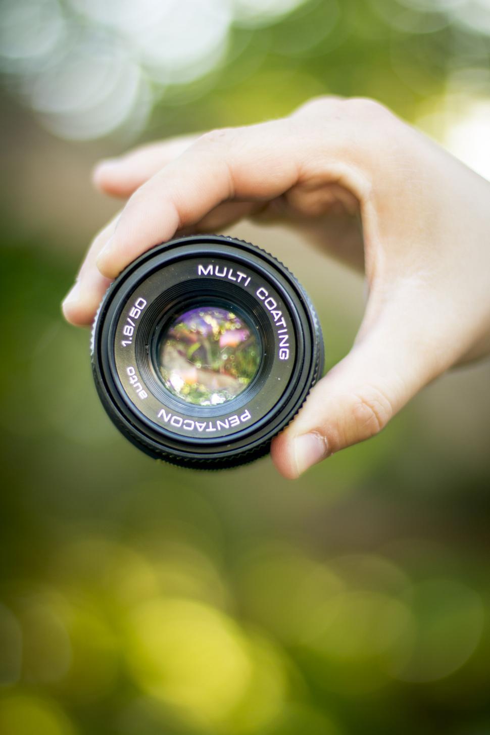 Free Image of A hand holding a camera lens 