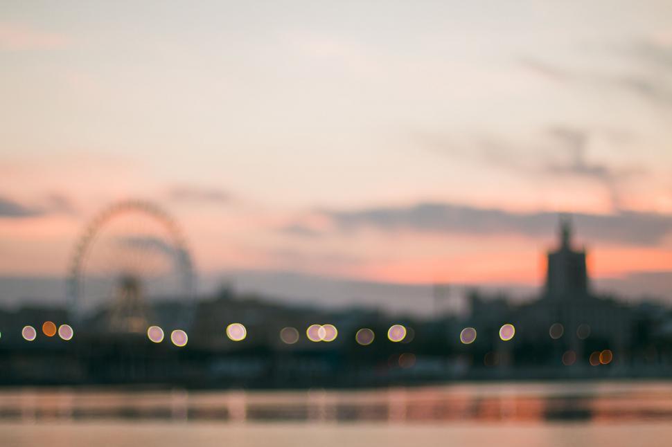 Free Image of A blurry image of a city with a ferris wheel in the background 