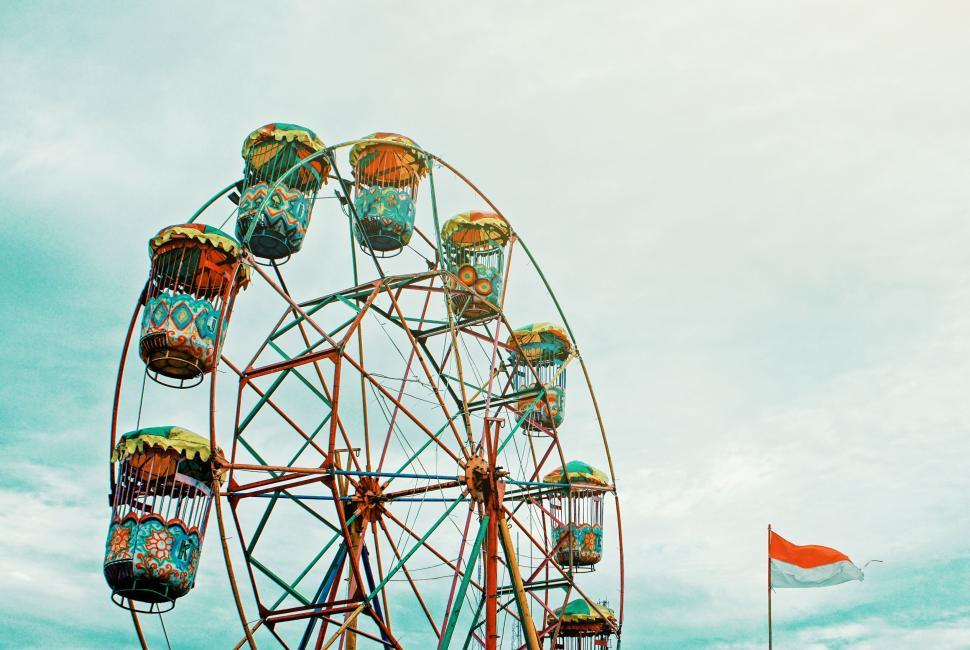 Free Image of A ferris wheel with a flag in the background 