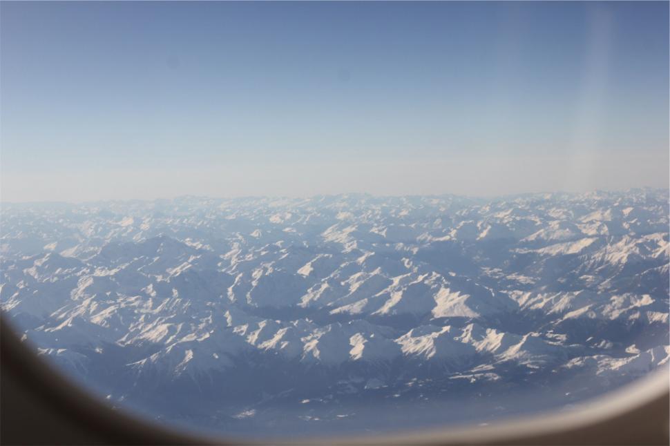 Free Image of A view of snow covered mountains from an airplane window 