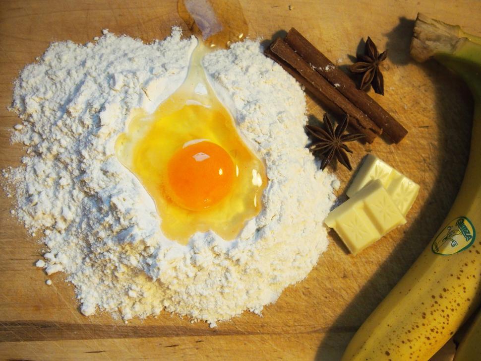 Free Image of A egg yolk and flour on a cutting board 