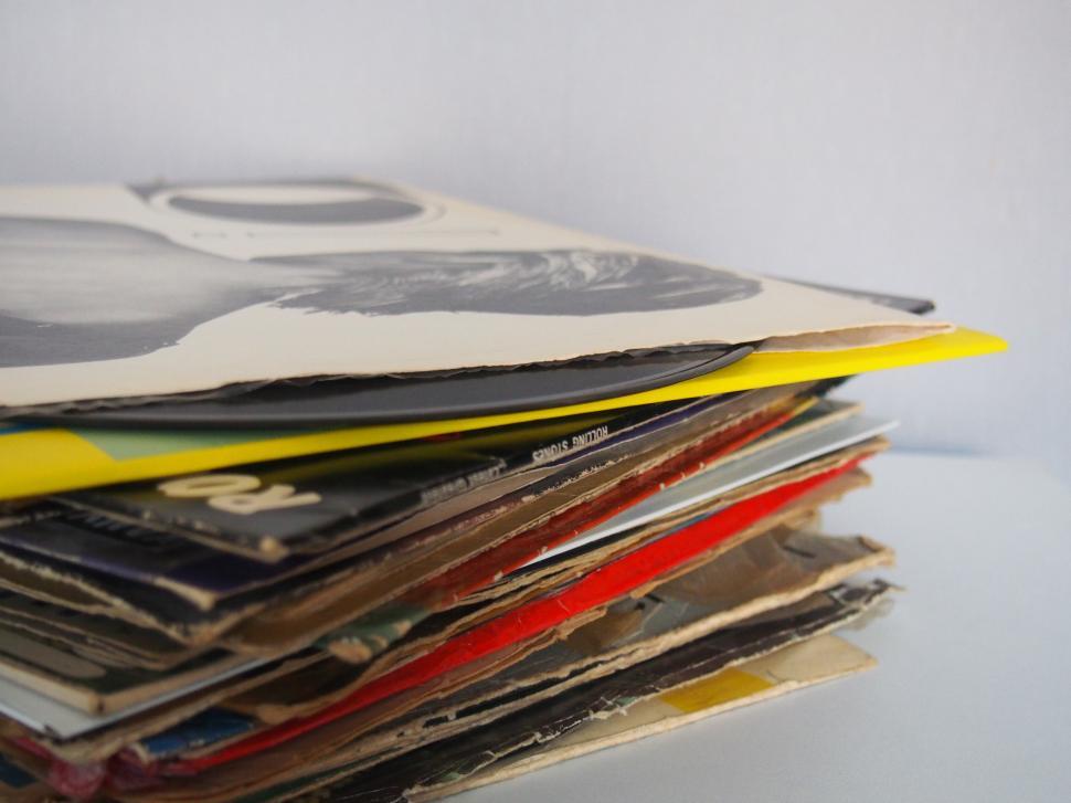 Free Image of A stack of records on a white surface 
