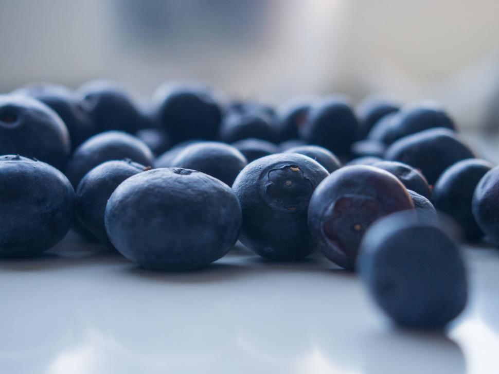 Free Image of A group of blueberries on a white surface 