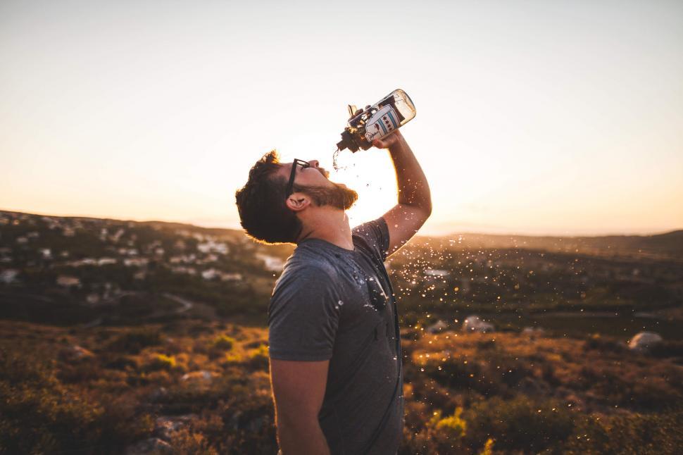 Free Image of A man drinking water from a bottle 