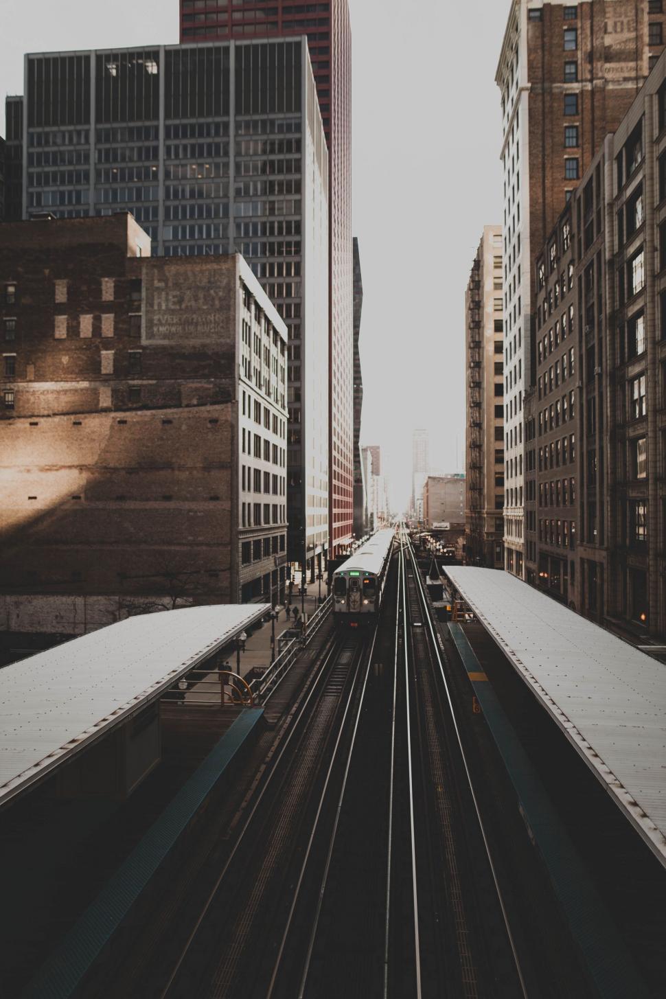 Free Image of A train going down a train track in a city 