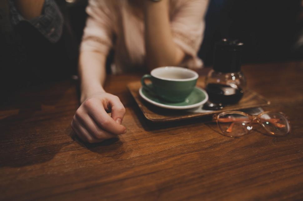 Free Image of A hand on a table with a cup and saucer 