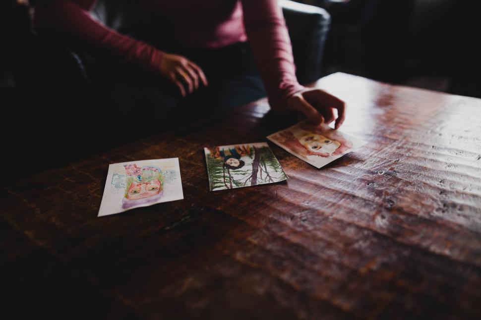 Free Image of A person sitting at a table with pictures on them 