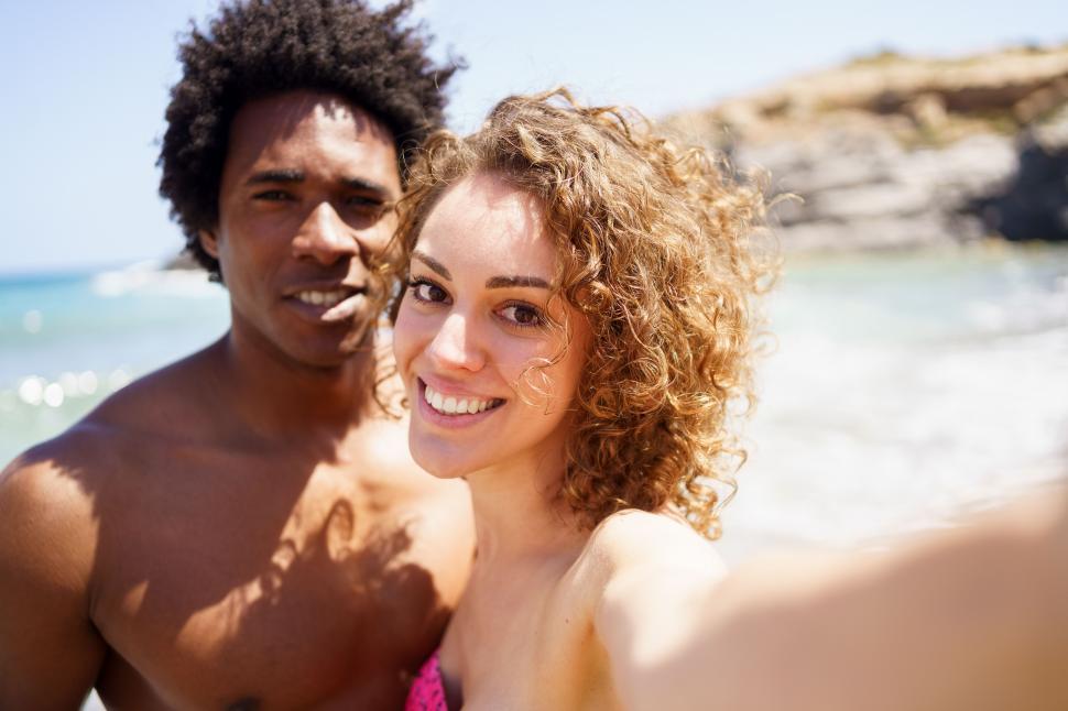 Free Image of Selfie of happy diverse couple on beach 