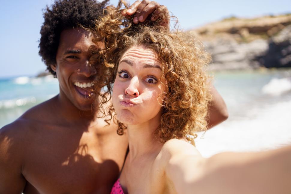 Free Image of Selfie of funny diverse couple on seashore 
