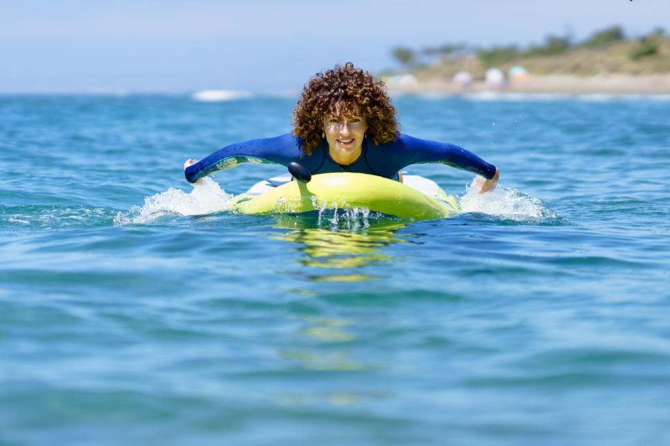 Free Image of Woman swimming on paddleboard in sea 