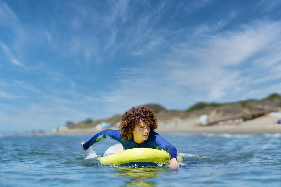Free Image of Fit woman on paddleboard rowing with hands in ocean 