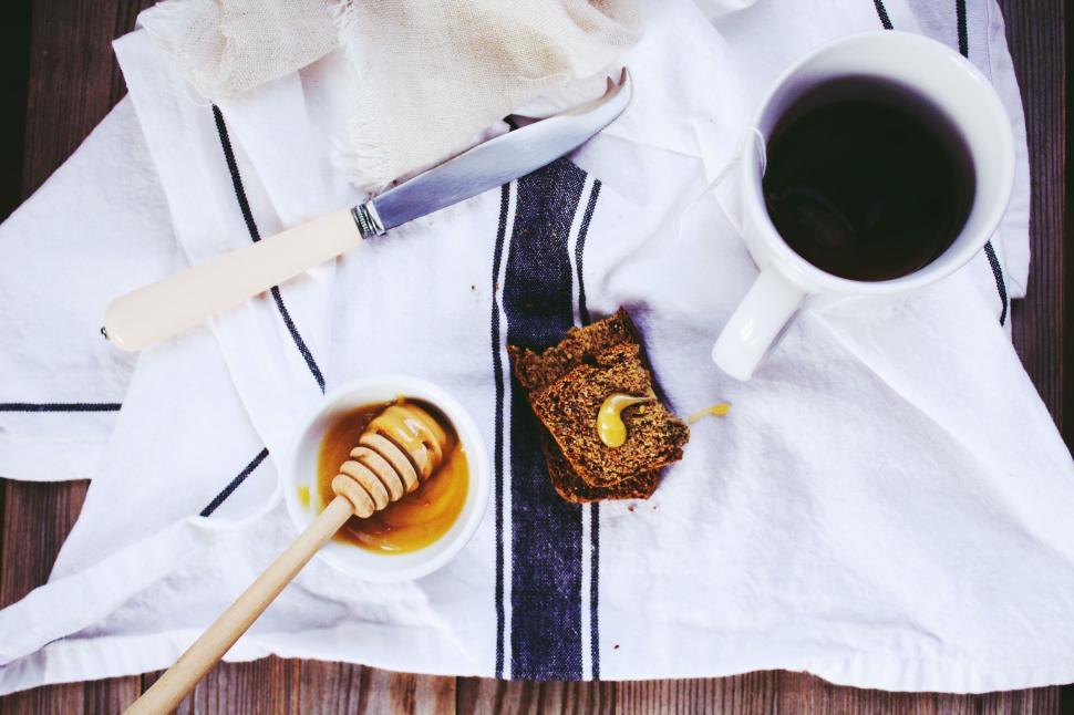 Free Image of A cup of coffee and honey on a towel 