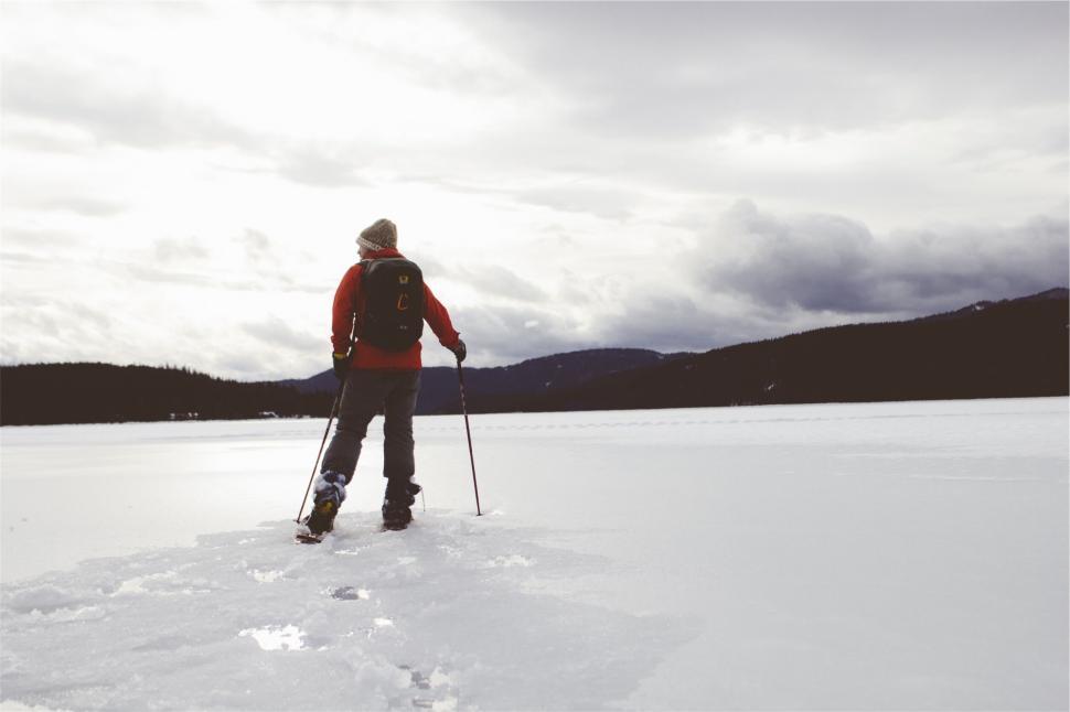 Free Image of A person in snow shoes and backpack walking on snow 