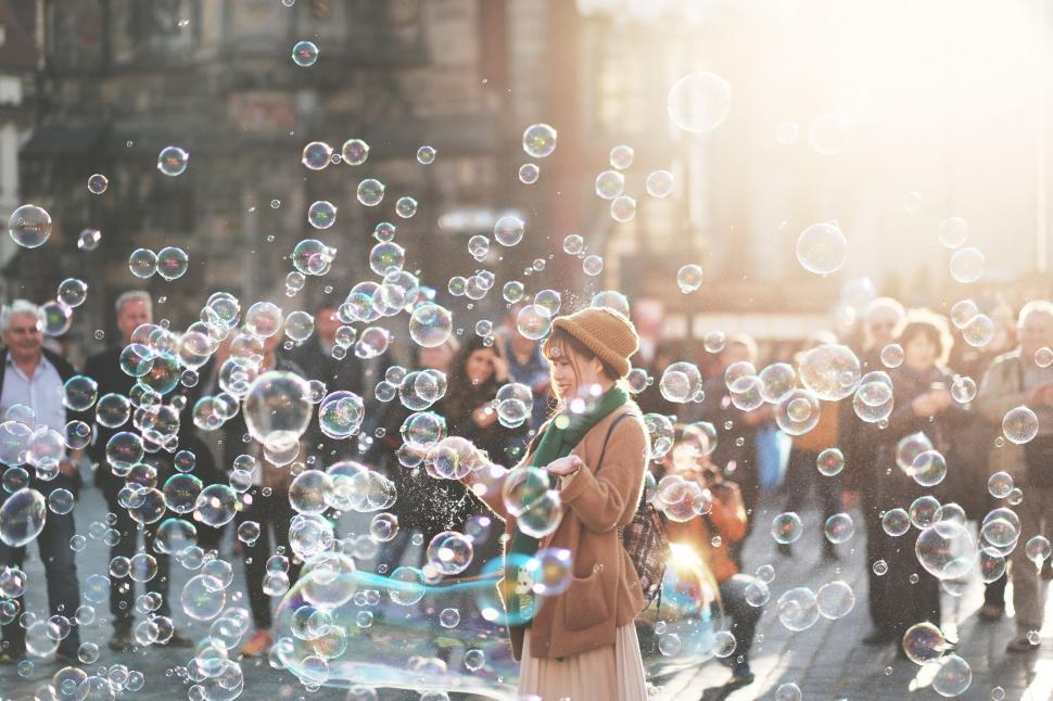 Free Image of A woman standing in front of a crowd of bubbles 
