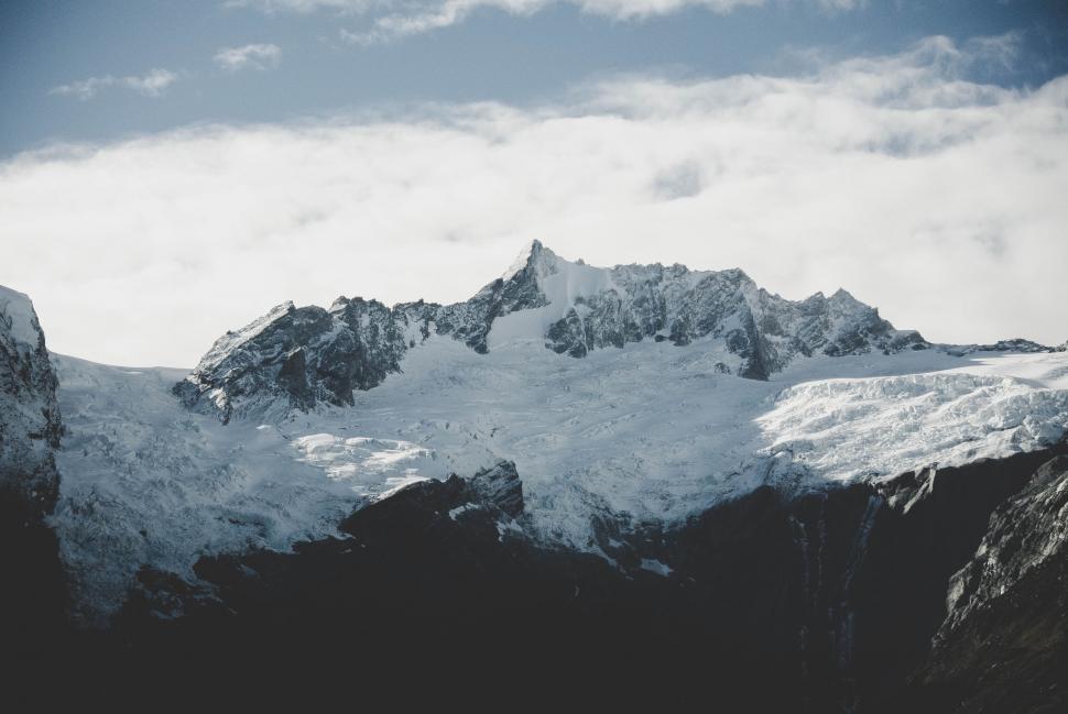 Free Image of A snowy mountain with clouds in the sky 