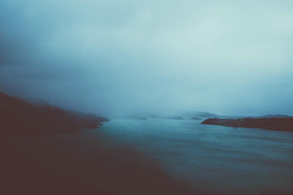 Free Image of A body of water with trees and fog 