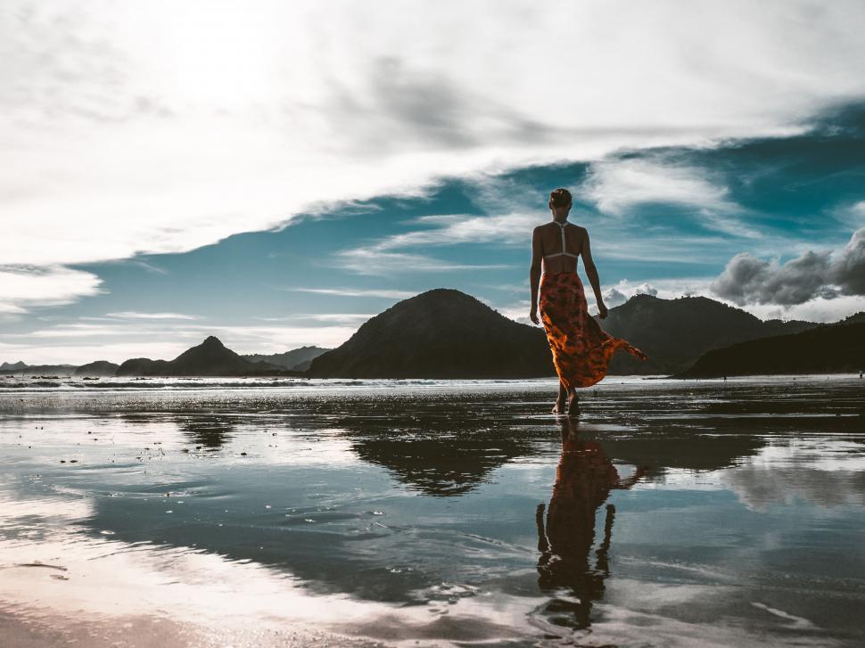 Free Image of A woman walking on a beach 