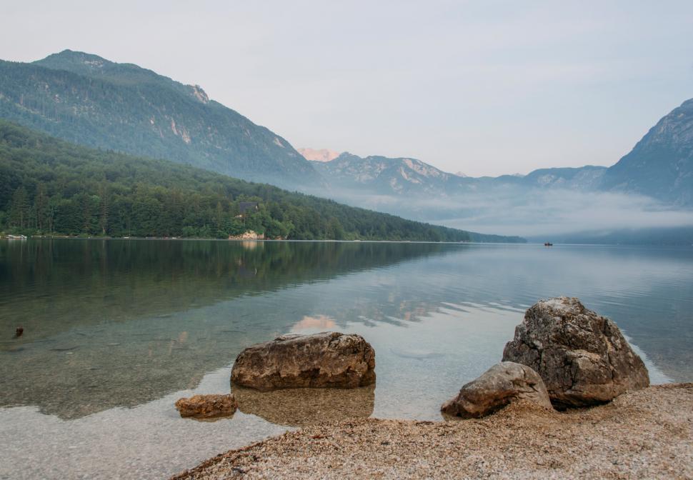 Free Image of A lake with rocks and mountains in the background 