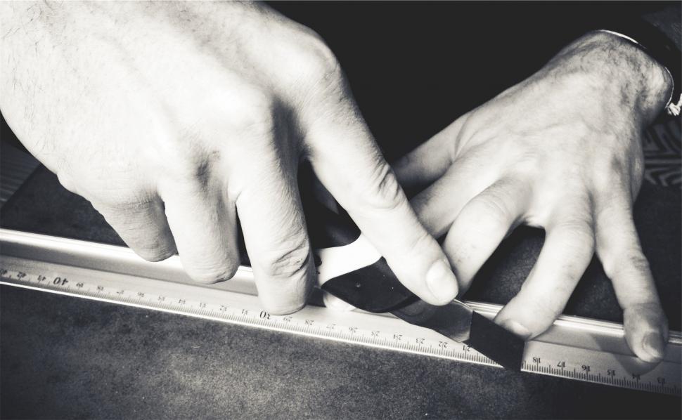 Free Image of A person using a ruler to cut a piece of paper 