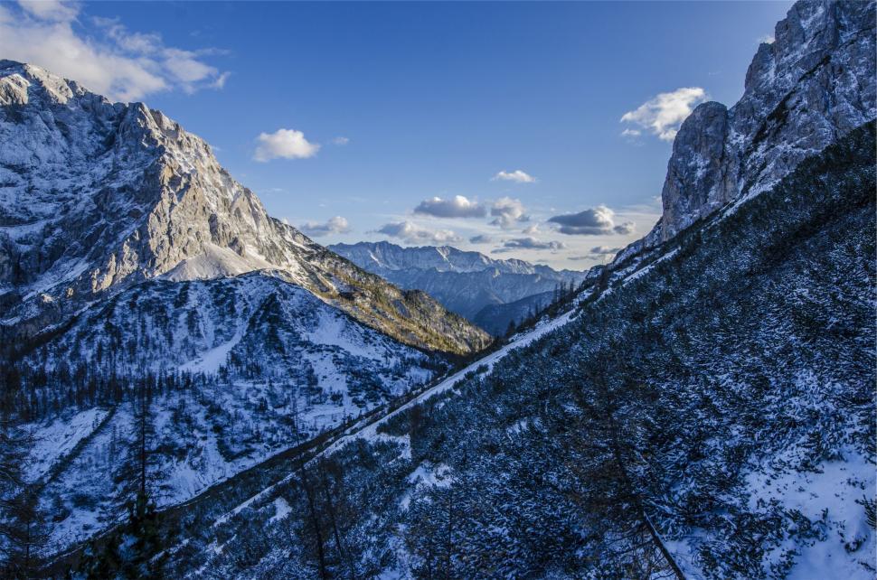 Free Image of A snowy mountain range with a rocky peak 