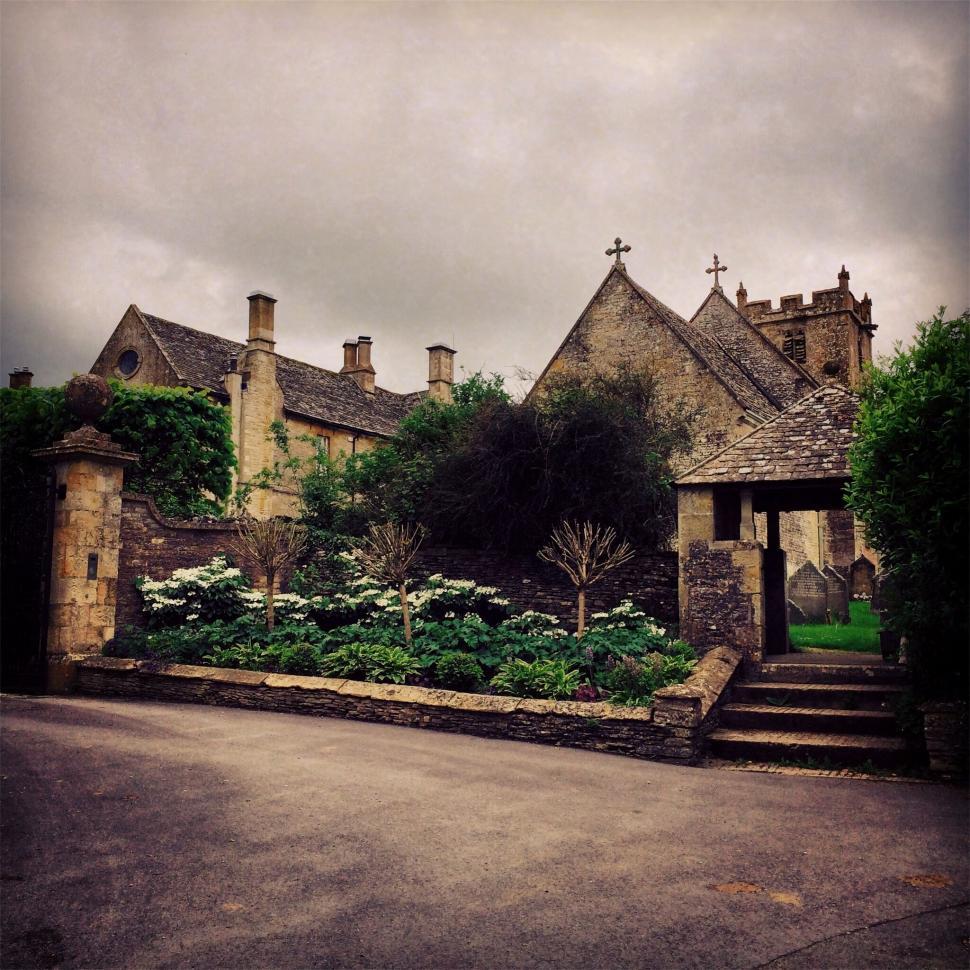 Free Image of A stone building with a garden and a stone gate 