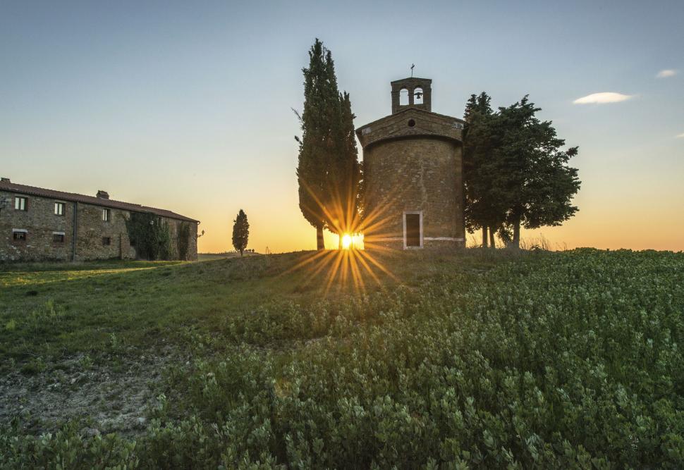Free Image of A building with a bell tower and trees in a field 