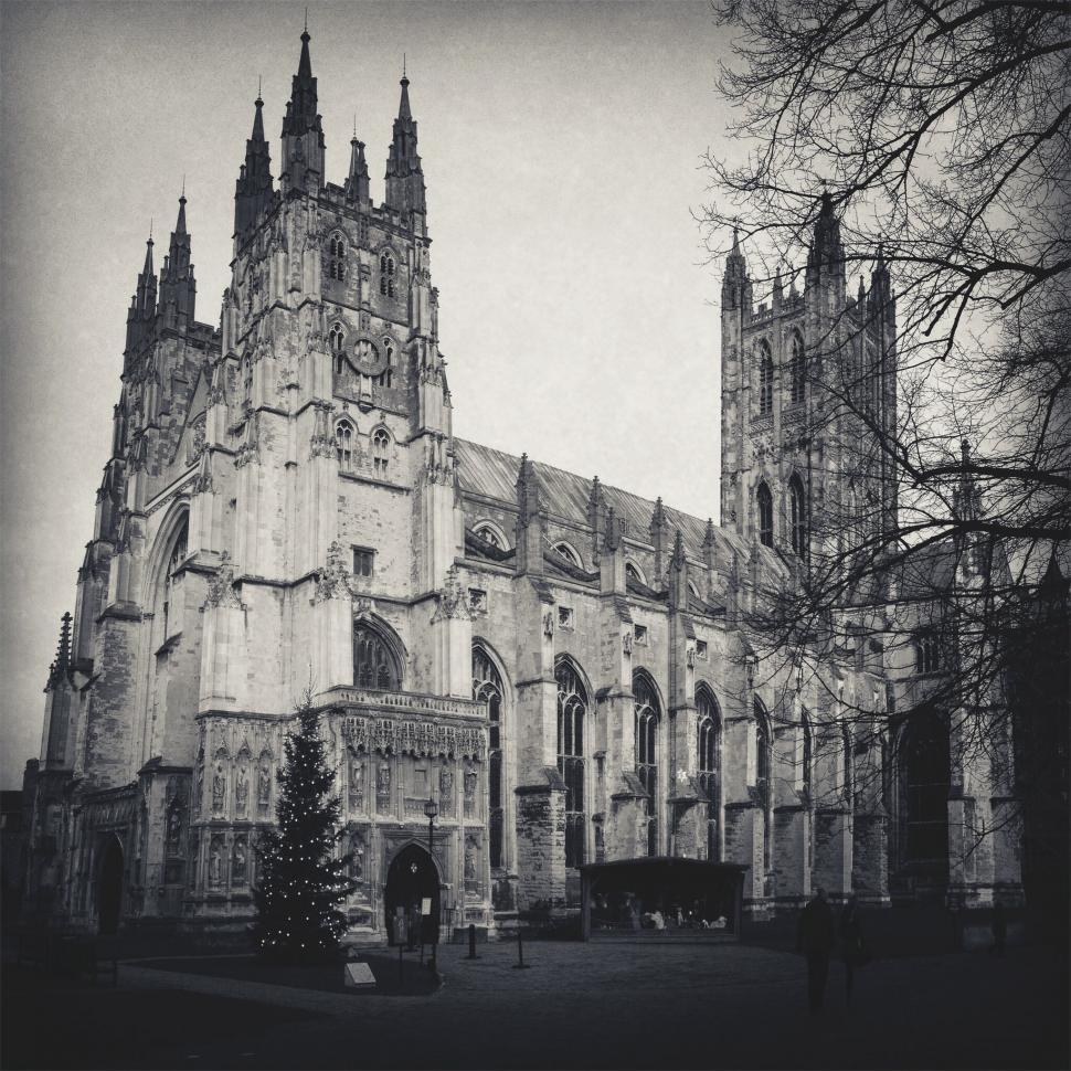 Free Image of A large building with towers and trees with canterbury cathedral in the background 