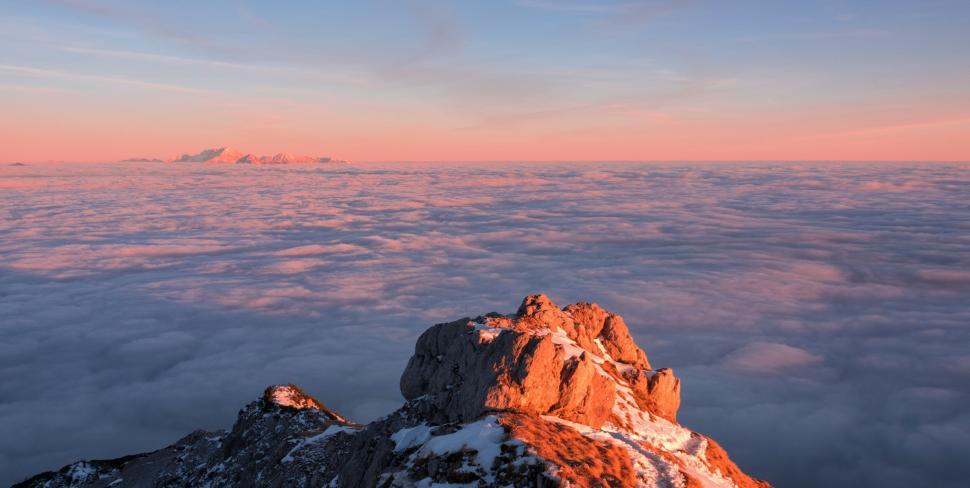 Free Image of A mountain peak with clouds above 