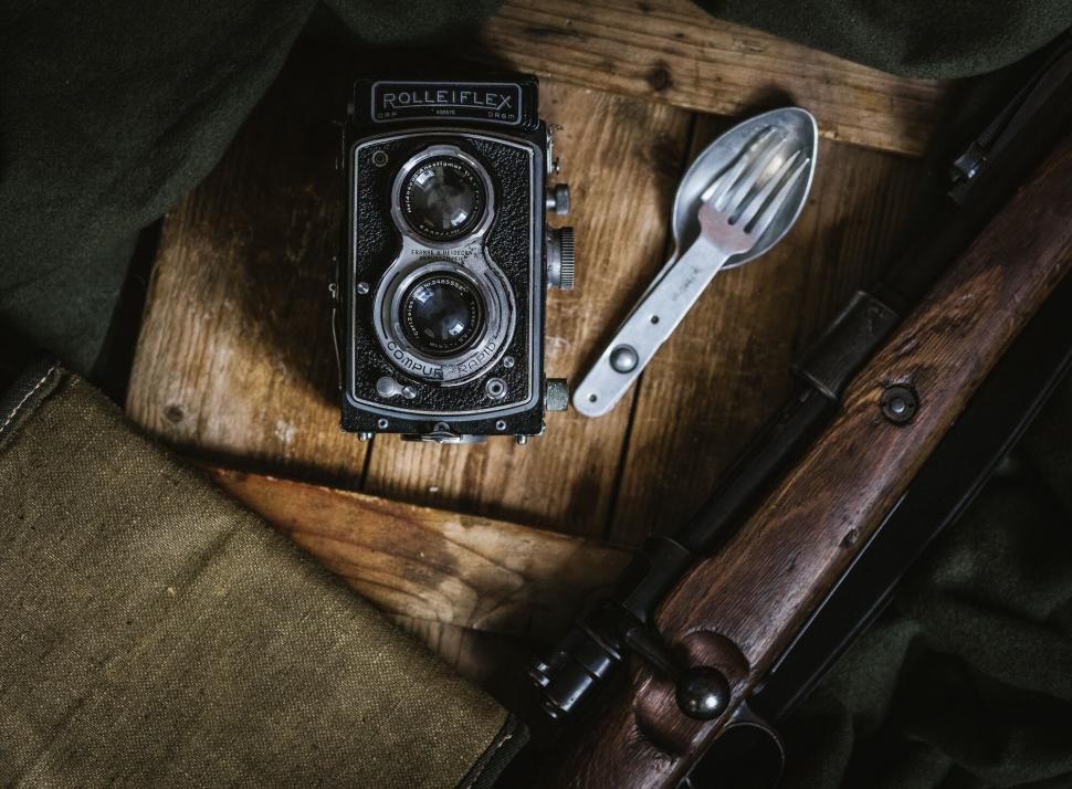 Free Image of A camera and a spoon on a wooden surface 