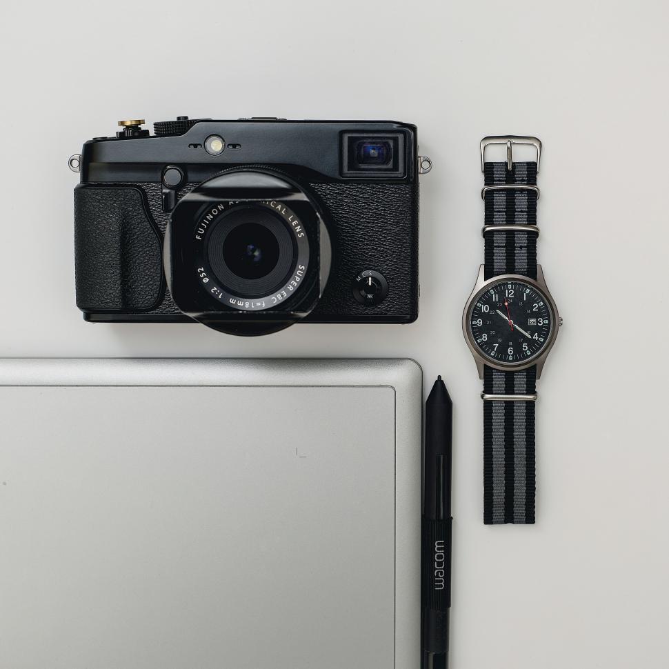 Free Image of A camera and a watch next to a laptop 