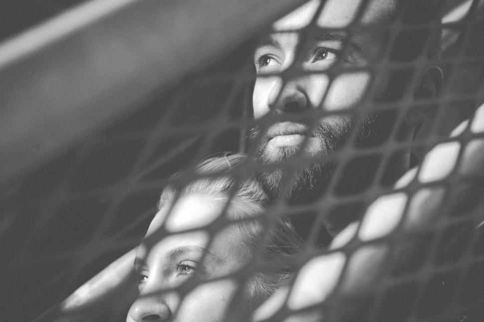 Free Image of A man and woman looking through a net 