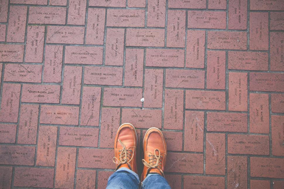 Free Image of A person s feet on a brick floor 