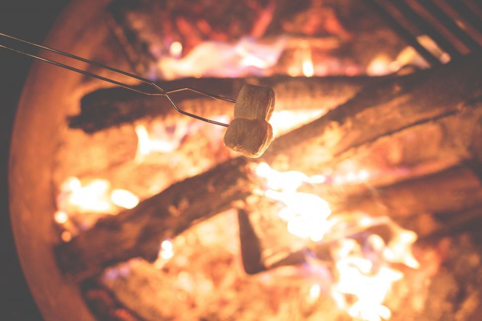 Free Image of Marshmallows over a campfire with a fire in the background 