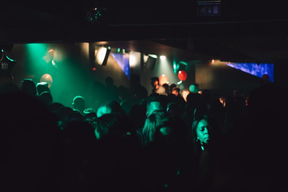 Free Image of A crowd of people in a dark room with green lights 